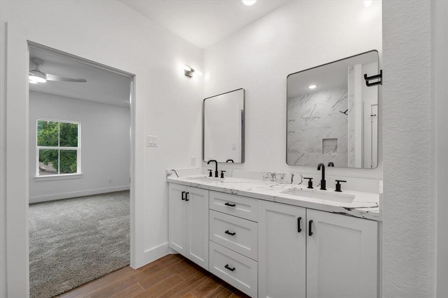 Dual vanities in the primary bathroom, with plenty of storage space and decorative lighting.