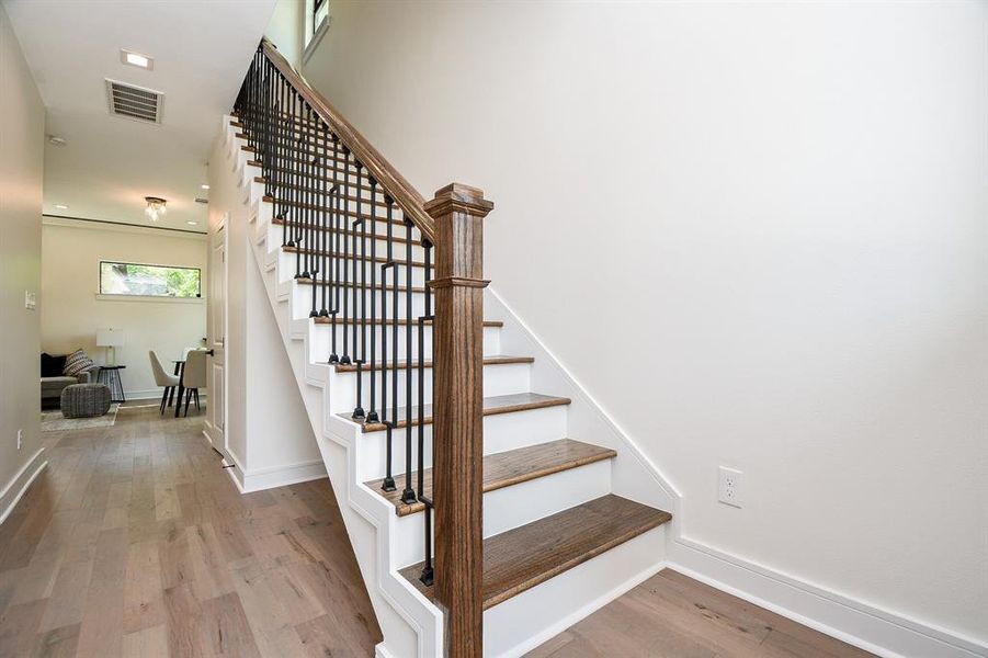 Upon entry, you will see that these really are different. Instead of short half walls and plain painted handrails plus carpet, a full staircase with iron railings and hardwood treads greets you and your guests