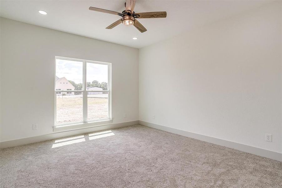 Carpeted spare room featuring ceiling fan