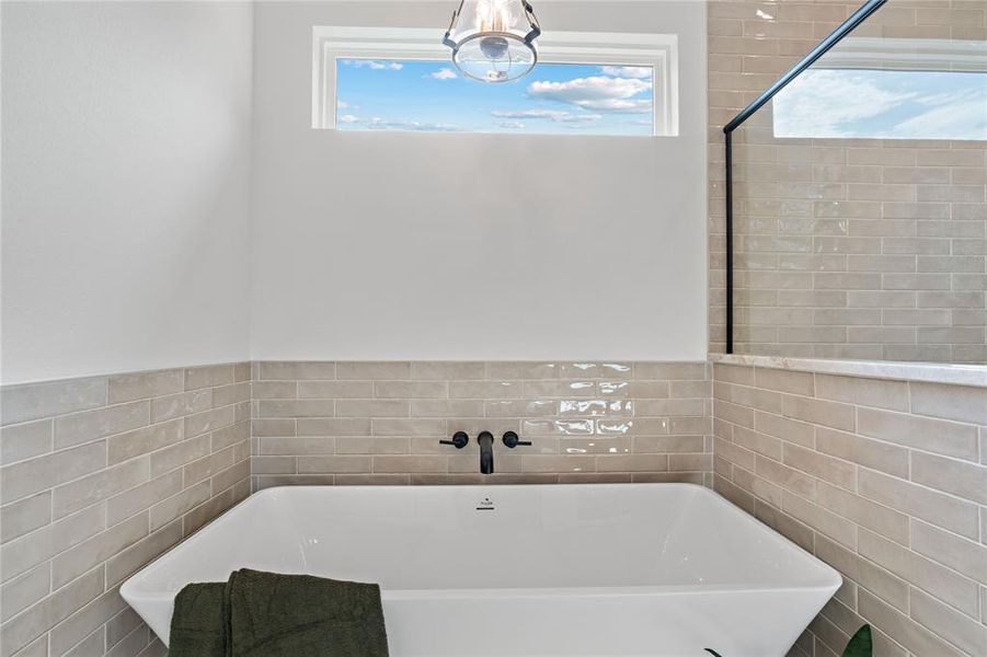 Bathroom featuring tile walls and a washtub