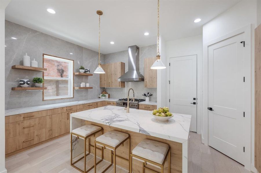 This designer kitchen features waterfall countertops and ceiling height backsplash.