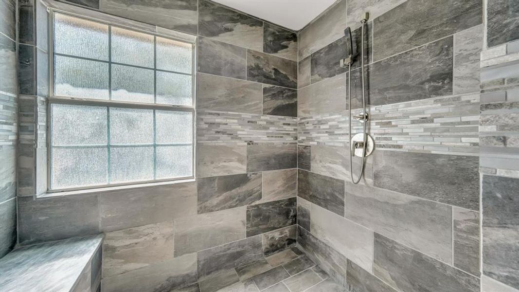 Bathroom featuring tiled shower and plenty of natural light