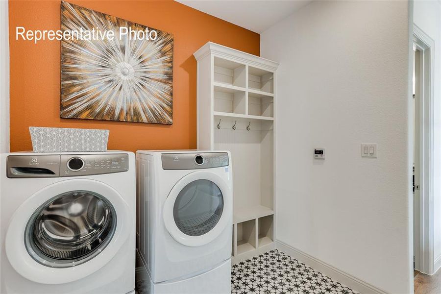 Washroom with washing machine and dryer and tile flooring