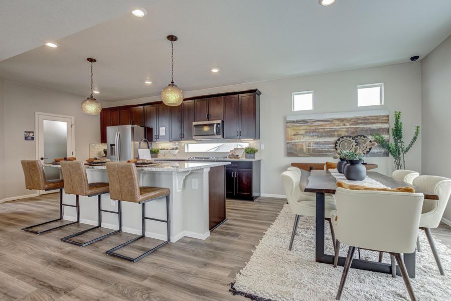 Indulge in culinary creativity and seamless entertaining in this stunning kitchen. Featuring an inviting eat-in island and sleek stainless-steel appliances, it's the perfect space to whip up delicious meals