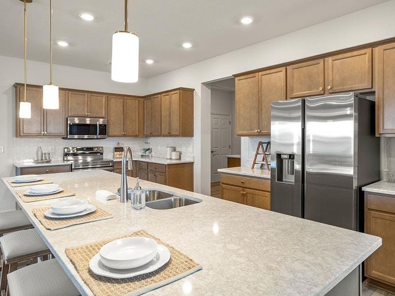 You will love the beautiful, open kitchen with an oversized counter-height island that can easily seat up to six - Summerlyn ll home plan by Highland Homes