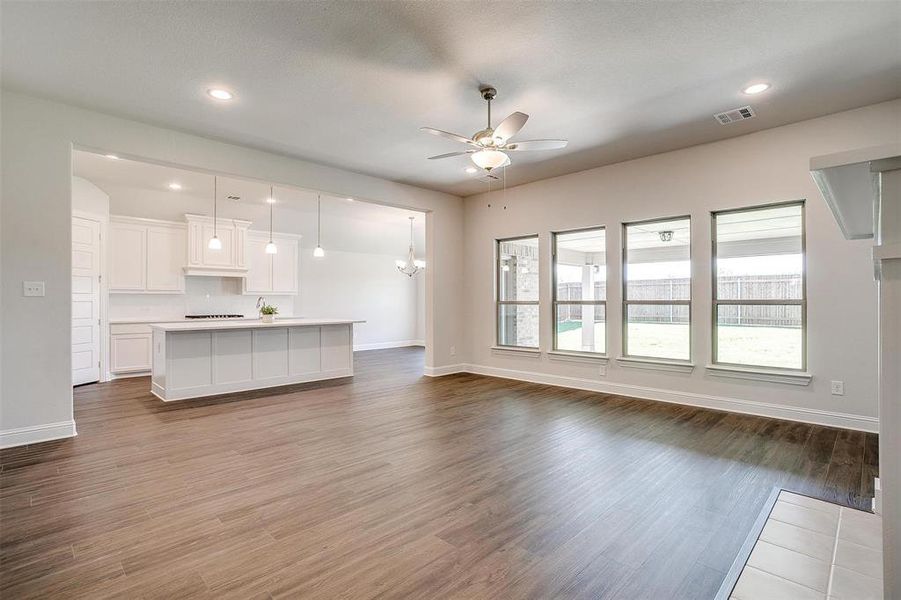 Unfurnished living room featuring ceiling fan and hardwood / wood-style flooring