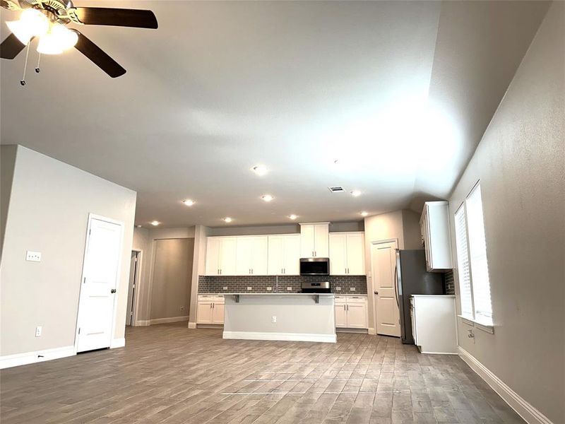 Kitchen featuring white cabinetry, light hardwood / wood-style floors, appliances with stainless steel finishes, and a center island