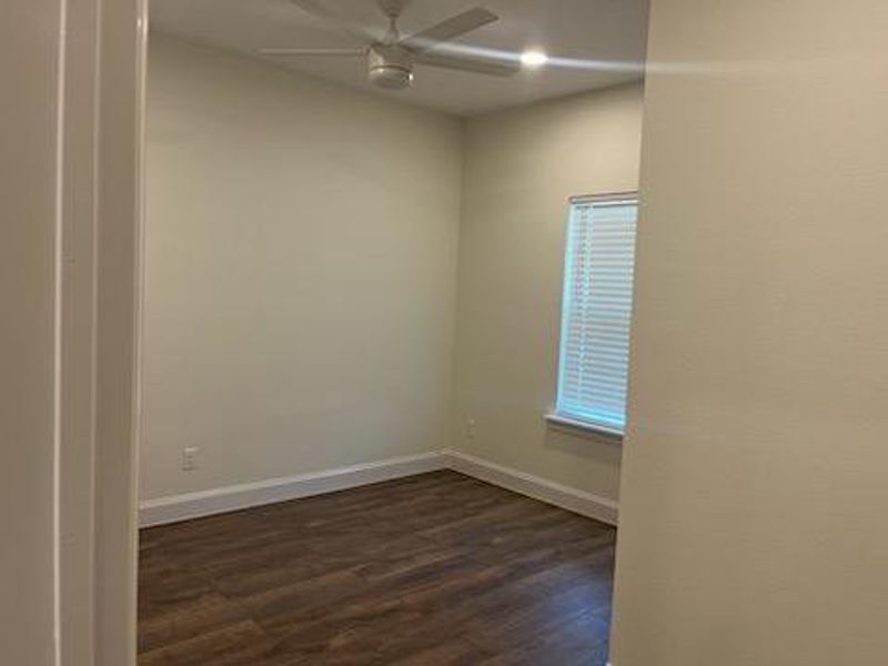 Unfurnished room with ceiling fan and dark hardwood / wood-style flooring