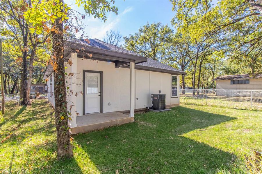 Rear view of house featuring a patio area, central AC, and a yard