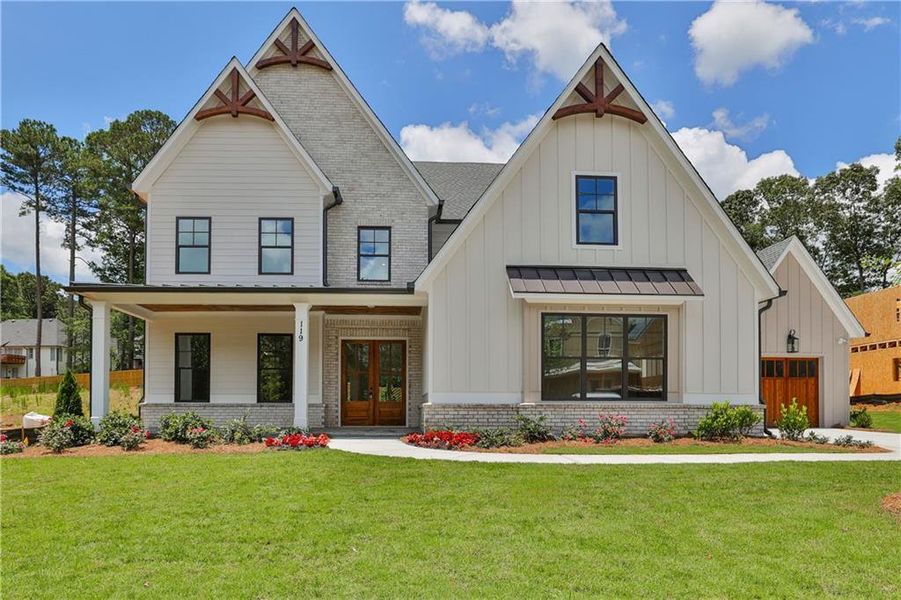 Modern farmhouse style home featuring a front yard. Picture of another property, same plan. Listing plan is a 4 car garage, not 3 as in picture