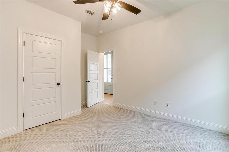 Unfurnished bedroom featuring light colored carpet and ceiling fan