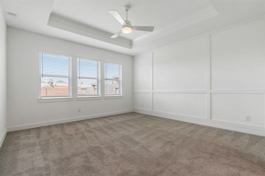 Large Primary bedroom with trayed ceiling, accent trim wall and lots of windows!