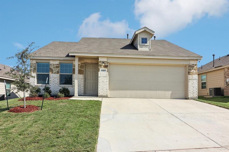 View of front of house with a garage, a front lawn, and central air condition unit