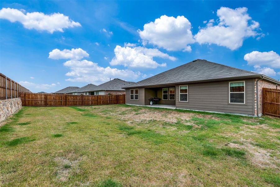 Back of house featuring a lawn and a patio area