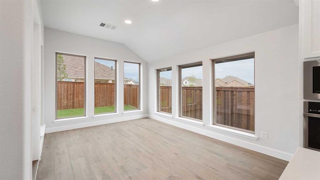 Unfurnished sunroom featuring lofted ceiling