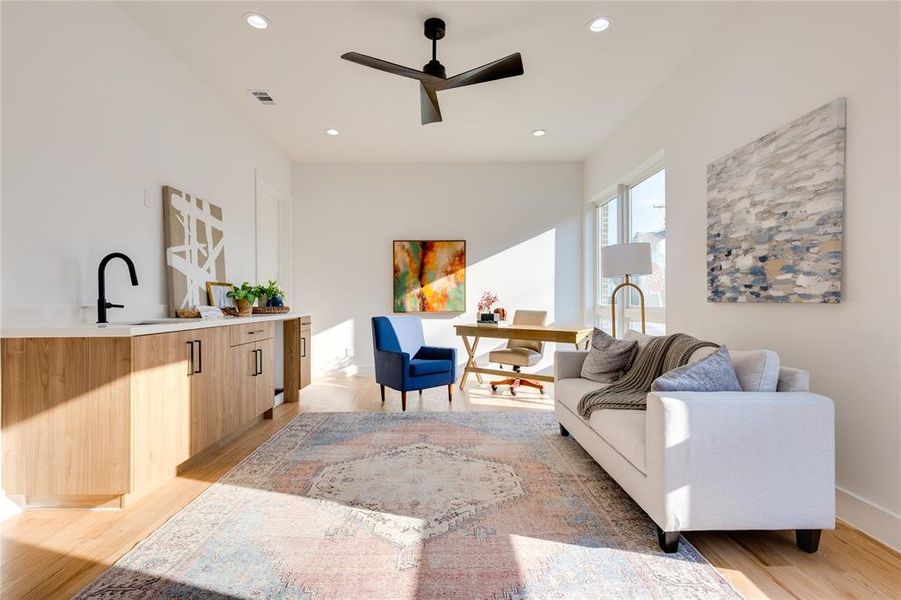 Living room featuring ceiling fan, light hardwood / wood-style flooring, and sink