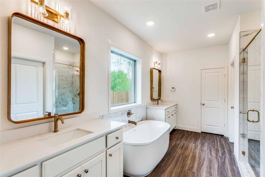 Bathroom with plus walk in shower, double sink vanity, and hardwood / wood-style floors