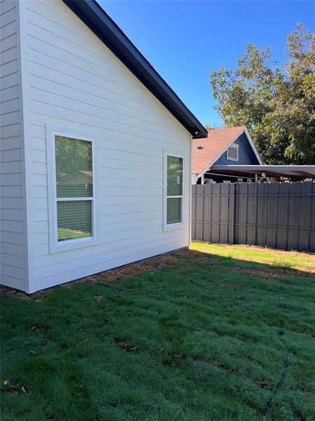 View of side of property featuring a lawn