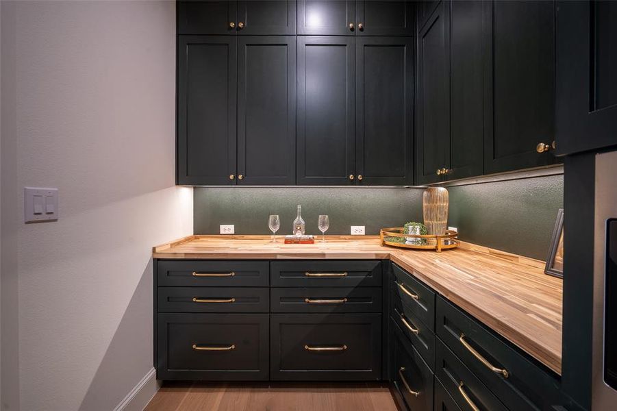 Pantry with butcher block counters and light hardwood / wood-style floors