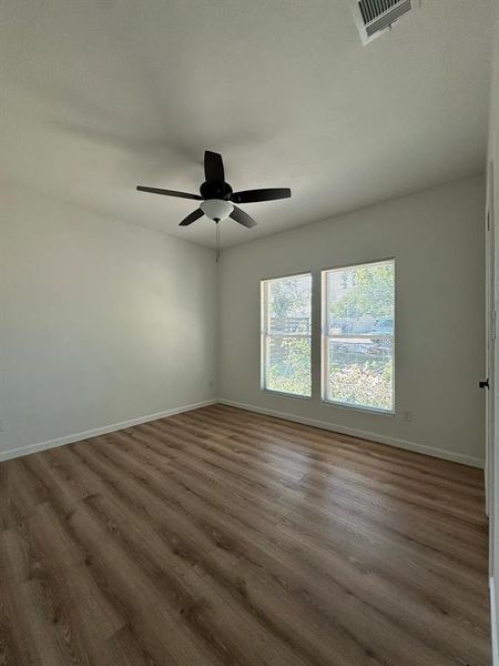 Unfurnished room featuring dark wood-type flooring and ceiling fan