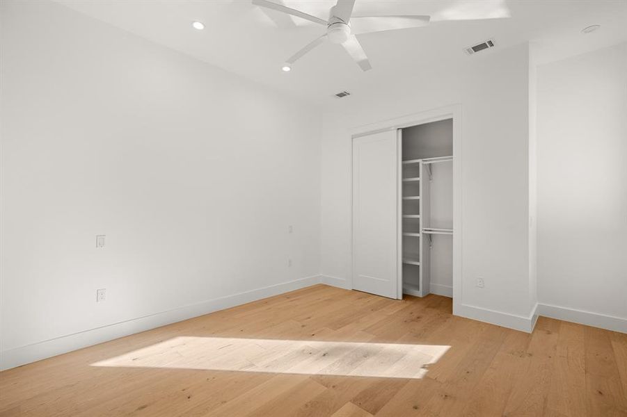 The main floor also provides this bonus 4th bedroom or guest room with a closet and modern ceiling fan. This rooms is tucked away in the hallway to the primary suite.
