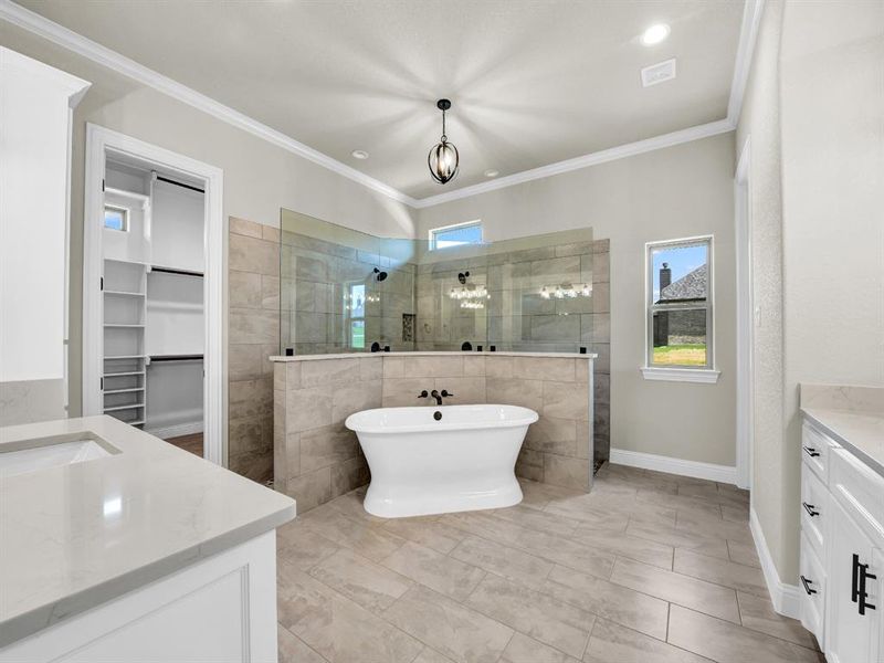 Bathroom with ornamental molding, vanity, and plus walk in shower