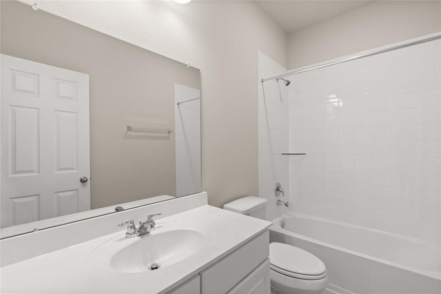 The secondary bath features tile flooring, white cabinetry and light countertops and a shower/tub combo. Perfect for accommodating any visiting family and friends.