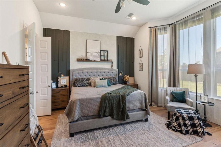 Bedroom featuring vaulted ceiling, light wood-type flooring, and ceiling fan