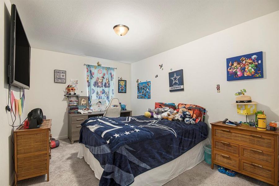 Bedroom with a textured ceiling and carpet