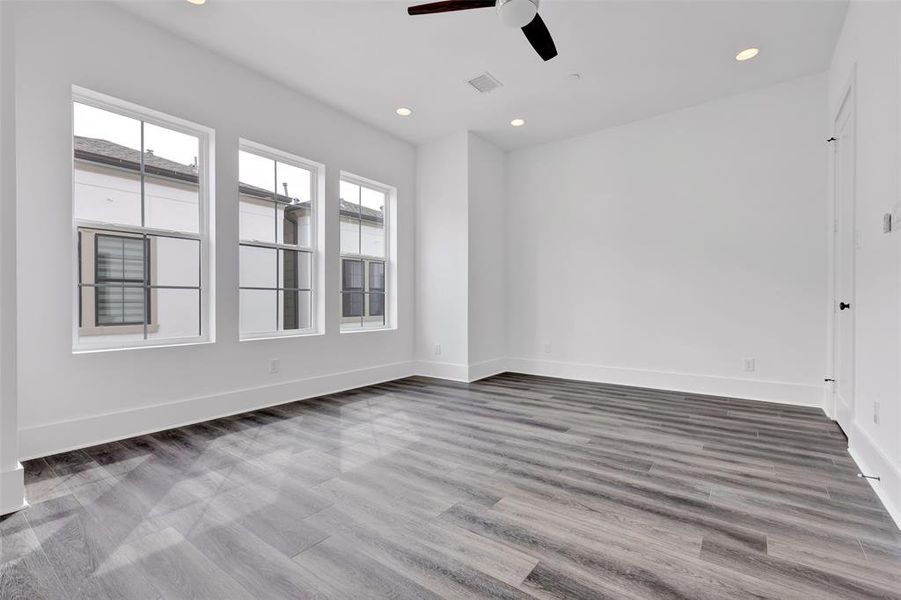 The bedroom on the fourth floor is bathed in natural light from its large windows, creating a bright and airy atmosphere.