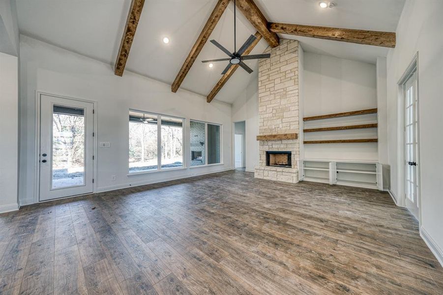 Big picture windows for all that natural light!  Stained beams, floor to ceiling stone fireplace, and floating shelves!