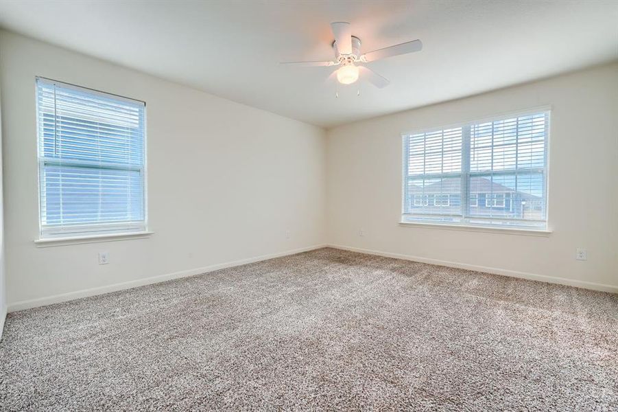 Spare room featuring carpet and ceiling fan