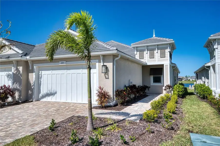 Exterior Front: Paving brick driveway, stucco exterior and a beautiful flat tile roof.