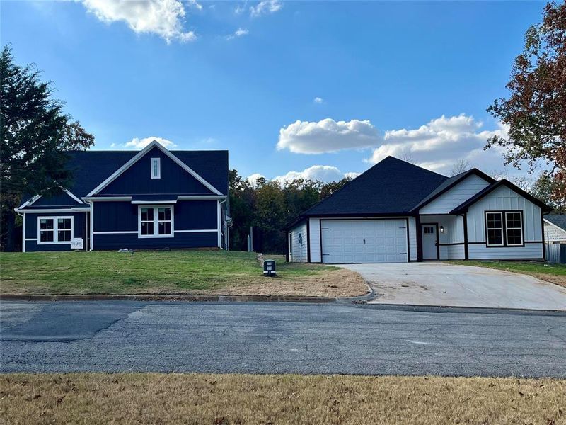 View of front of property featuring a front yard and a garage