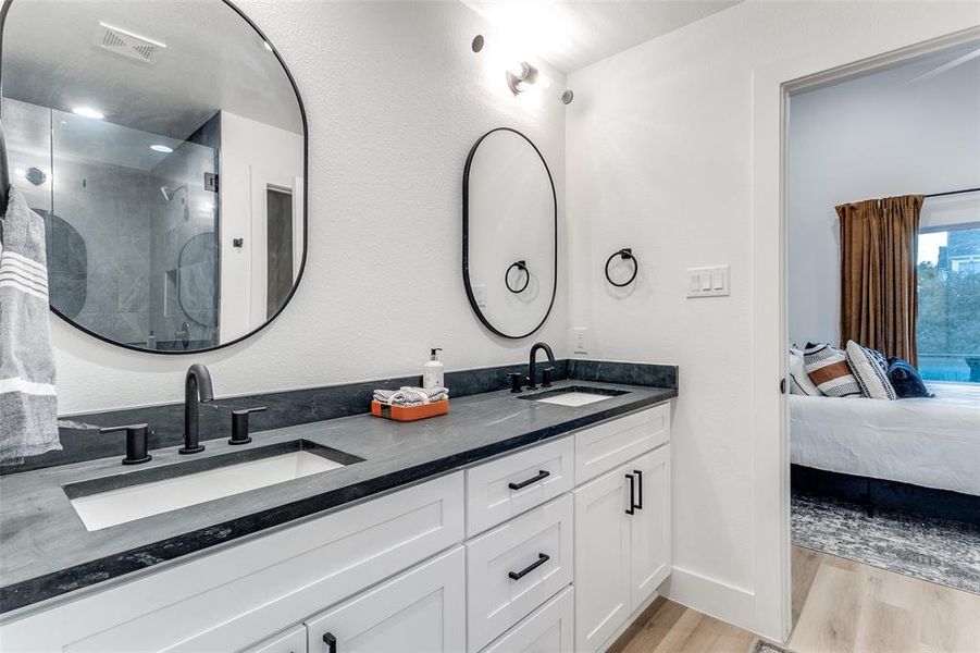 Bathroom featuring vanity, hardwood / wood-style floors, and a shower with shower door