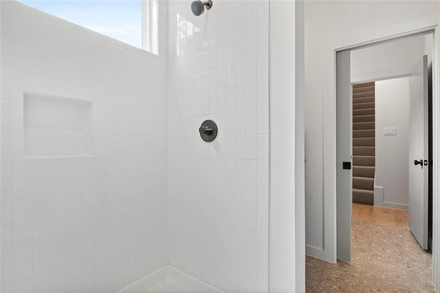 Bathroom featuring a tile shower and hardwood / wood-style floors