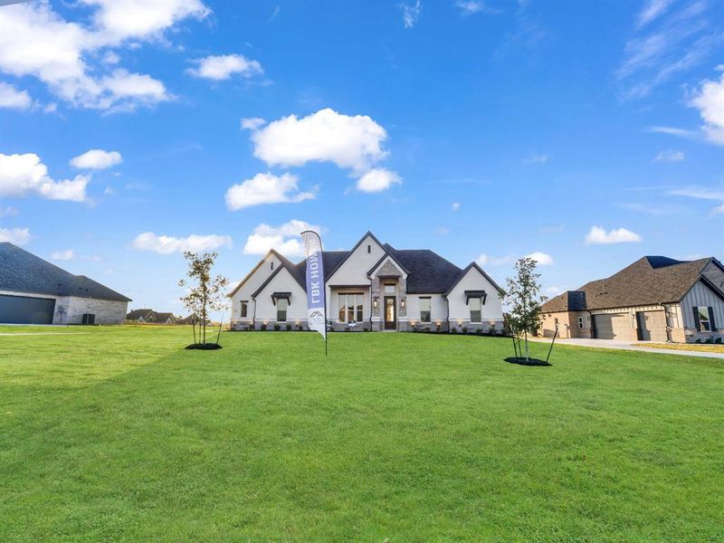 French provincial home with a front yard