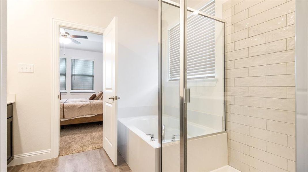 Bathroom with separate shower and tub, wood-type flooring, vanity, and ceiling fan