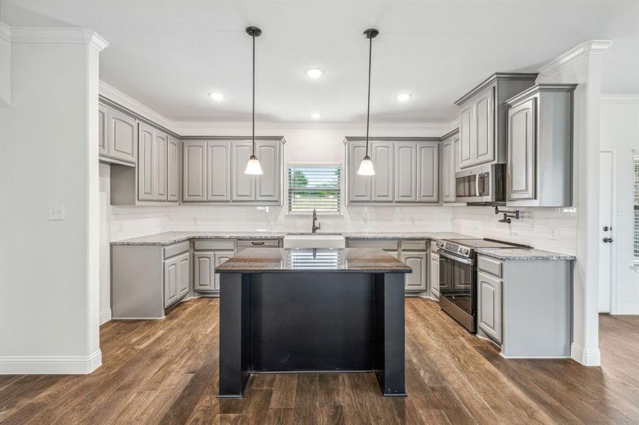 Kitchen featuring dark wood-type flooring, backsplash, gray cabinets, appliances with stainless steel finishes, and sink