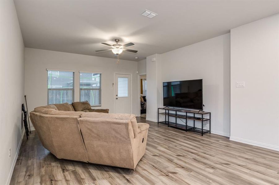 Living room with ceiling fan and hardwood / wood-style floors