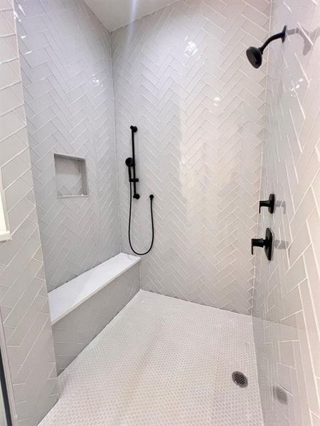 A modern bathroom featuring a shower stall designed for functionality and comfort.