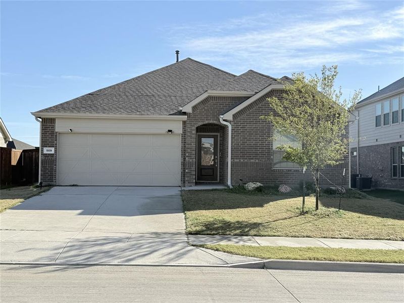 View of front of house with central AC unit, a garage, and a front yard