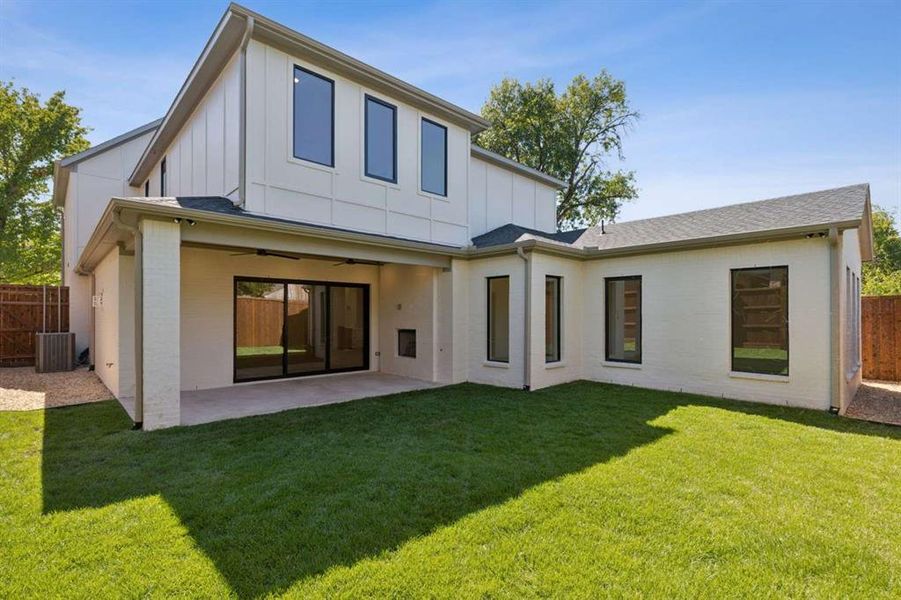 Back of property with a lawn and a patio area