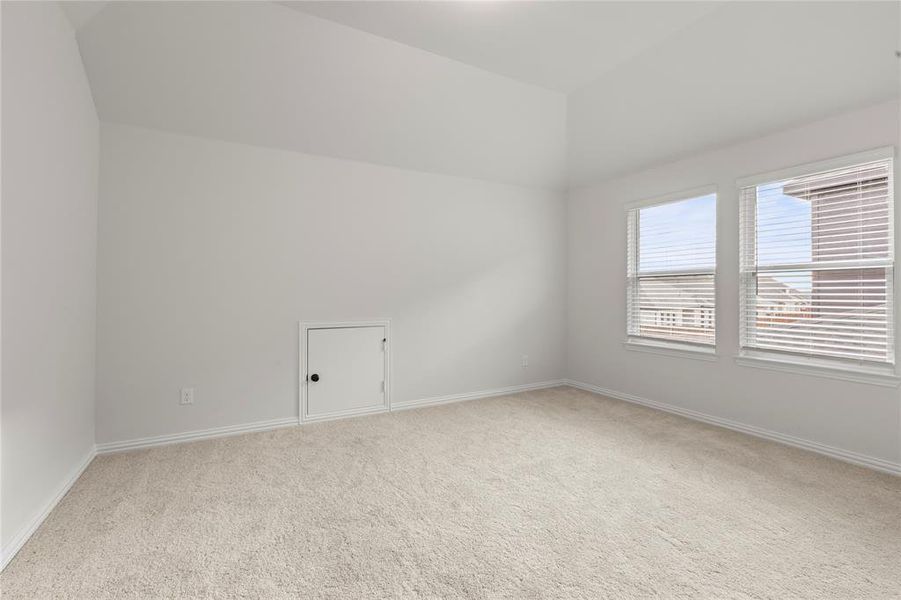 Unfurnished room featuring vaulted ceiling and light colored carpet