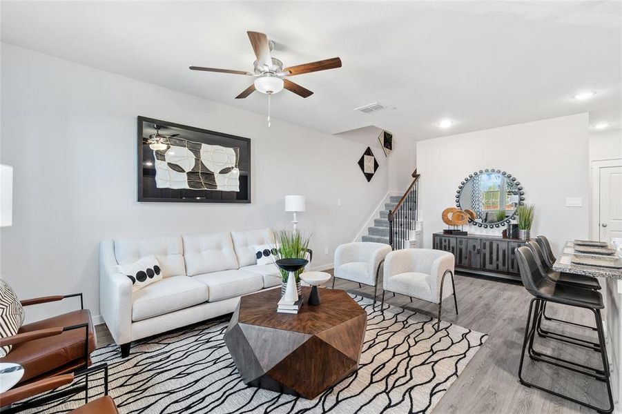 Living room with light hardwood / wood-style flooring and ceiling fan