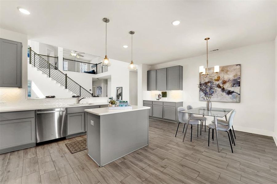 Kitchen featuring light wood-type flooring, gray cabinets, and stainless steel dishwasher