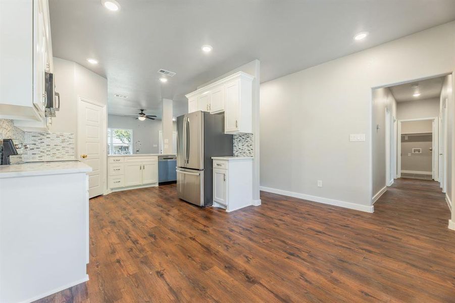 Kitchen with backsplash, stainless steel appliances, ceiling fan, and dark hardwood / wood-style floors