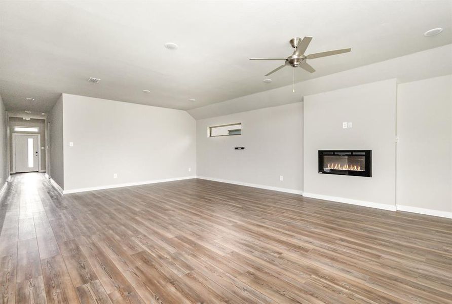 Unfurnished living room with ceiling fan and light wood-type flooring