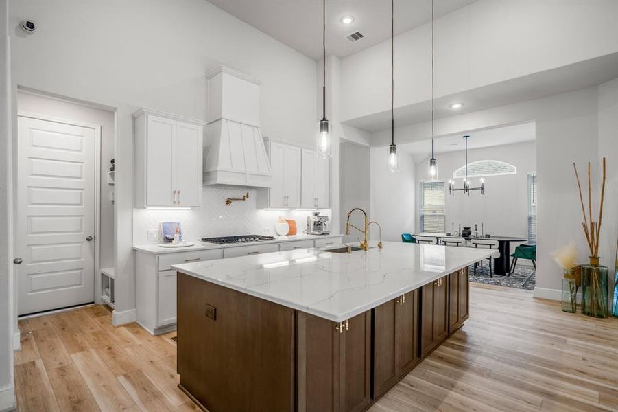 This stunning kitchen displays such a beautiful contrast with the white and wood cabinets, neutral paint, quartz, countertops, light modern backsplash, and SS appliances!