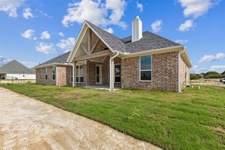 Back of property with a yard and a patio area